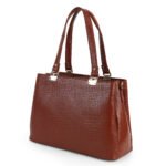 Blue croc-embossed leather handbag with double handles, placed in soft natural light with flowers nearby — a premium, handcrafted accessory by Dario Lario.