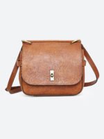 “Tan leather sling bag with gold hardware and front twist-lock closure against a light background.”