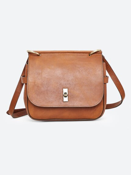 “Tan leather sling bag with gold hardware and front twist-lock closure against a light background.”