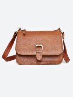 “Tan leather sling bag with gold hardware and front twist-lock closure against a light background.”