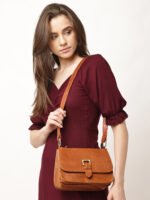 “Tan leather sling bag with gold hardware and front twist-lock closure against a light background.”