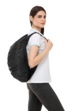 “Black leather travel bag worn over the shoulder by a model, featuring a soft structured design and zip compartments.”